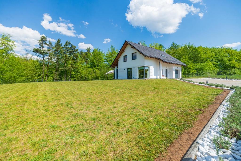 a house on a hill with a large yard at Peaceful house with sauna in Nowe Czaple