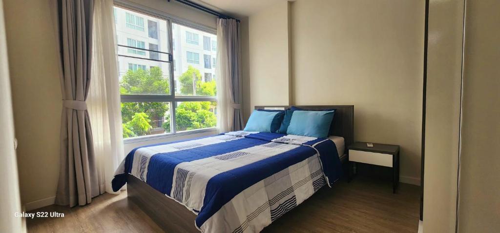 een slaapkamer met een bed en een groot raam bij An Na Park Hotel Room - Chiang Mai in Chiang Mai