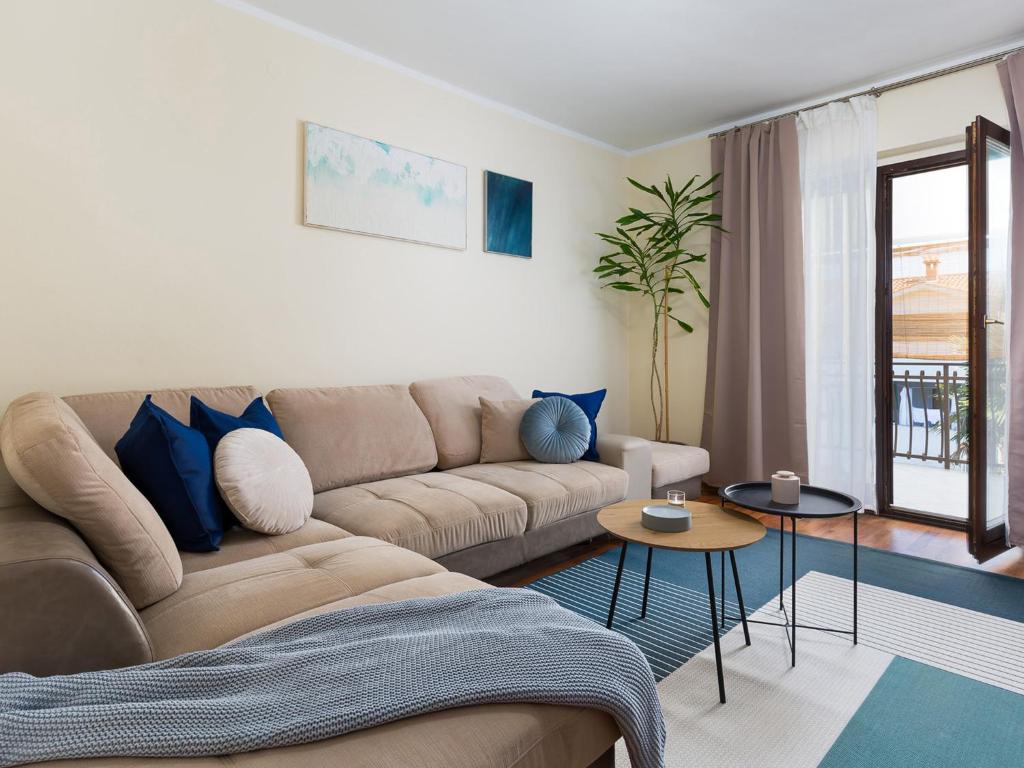 uma sala de estar com um sofá castanho e almofadas azuis em Marisan Seaview Apartment em Funtana