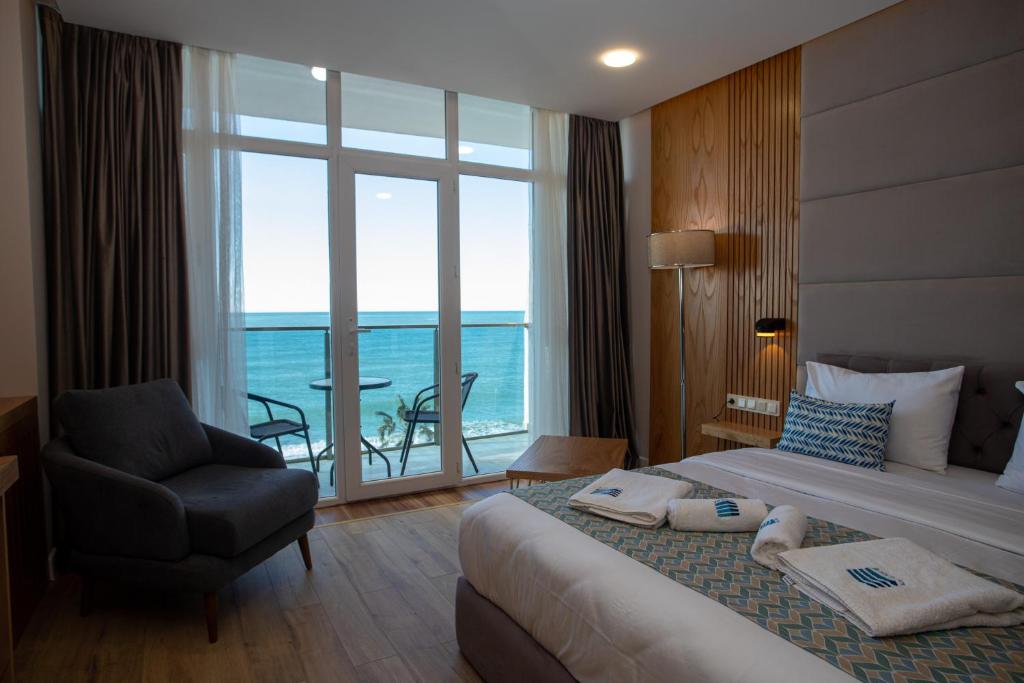 Pokój hotelowy z łóżkiem, krzesłem i oknem w obiekcie Hotel Black Sea w mieście Batumi
