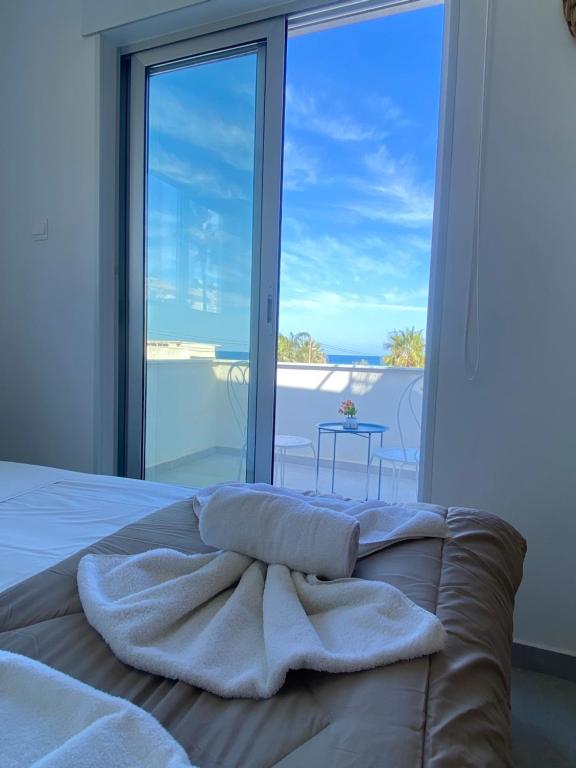 WAKE UP BY THE SEA FLATS في بروتاراس: غرفة نوم مع سرير وإطلالة على المحيط