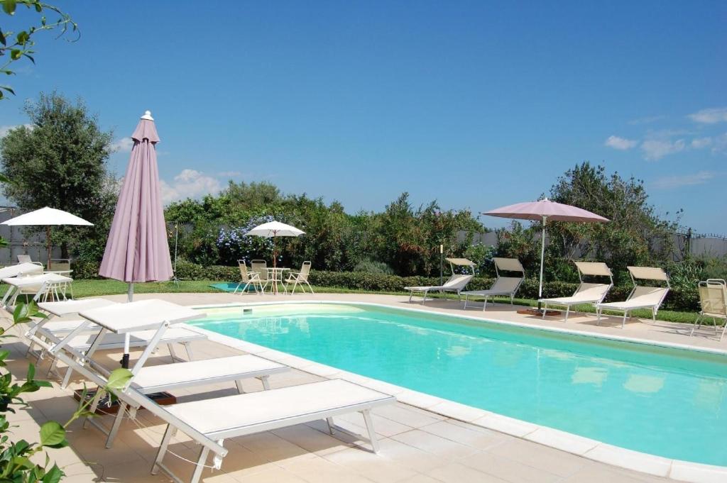 a swimming pool with lounge chairs and umbrellas at Apartment mit Terrasse - b57363 in Acireale