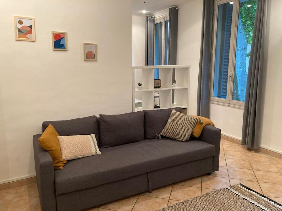 - un salon avec un canapé gris et des oreillers dans l'établissement Appartement cosy à 2 pas de la gare, à Marseille