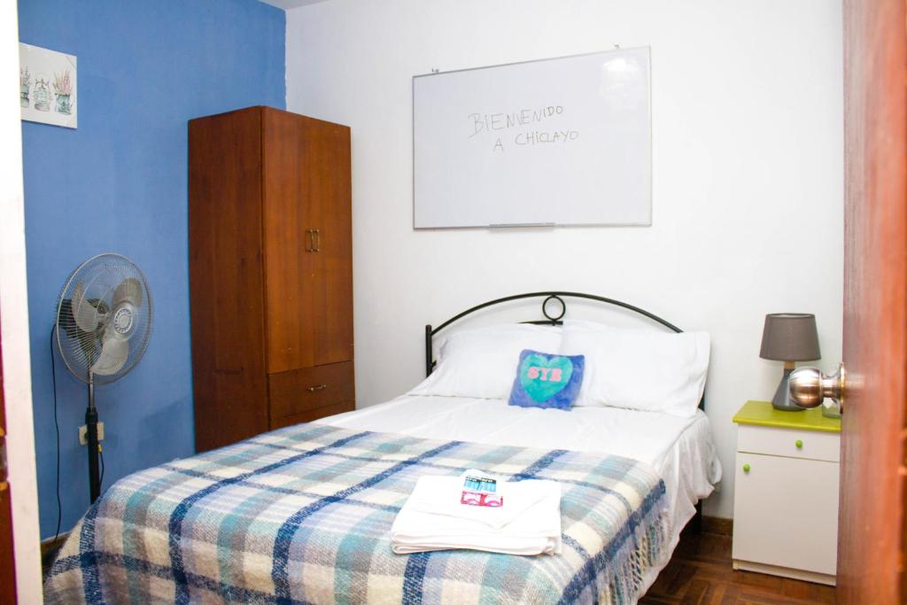 Habitación en Chiclayo (Santa Victoria) في تشيكلايو: غرفة نوم بسرير مع جدار ازرق