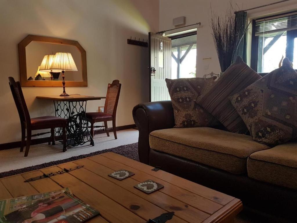 ein Wohnzimmer mit Sofa und Tisch in der Unterkunft Langford Executive Apartments in Bristol