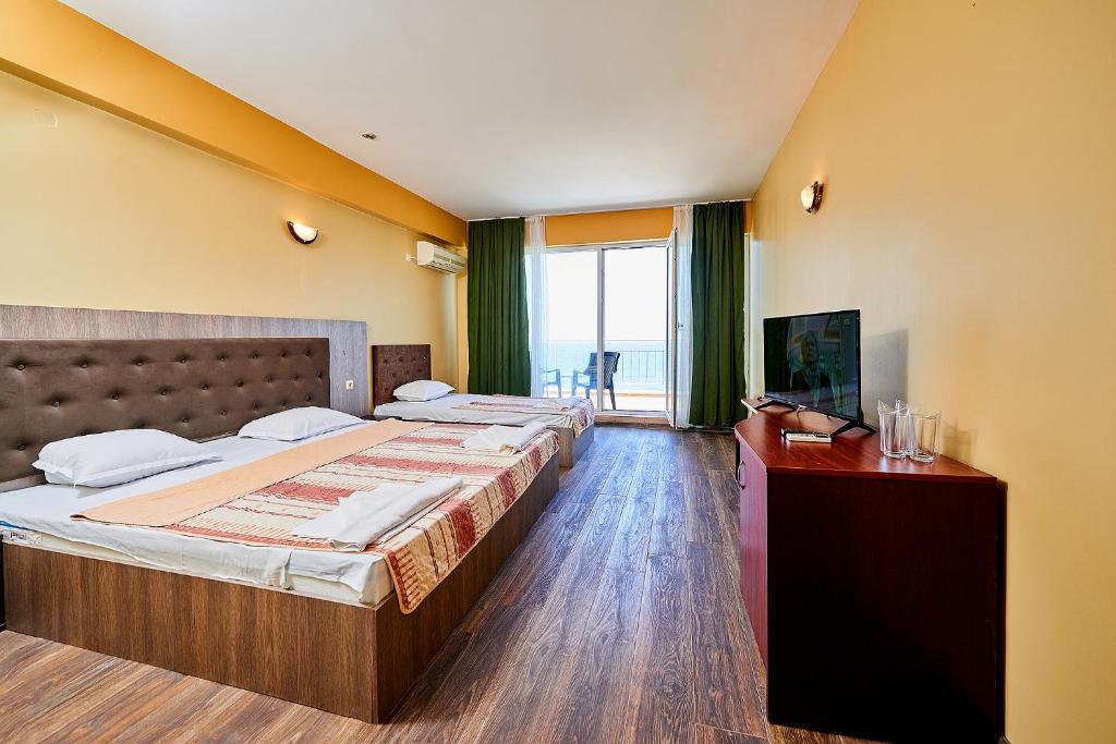 Habitación de hotel con 2 camas y TV en Complex Relax Pomorie All Inclusive, en Pomorie