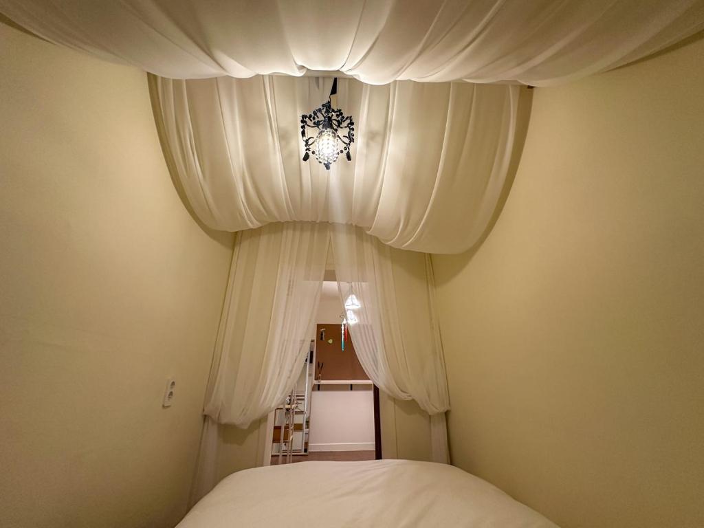 a bedroom with white curtains and a bed at Yunseul- Garden House in the City with Korean Beauty in Seoul
