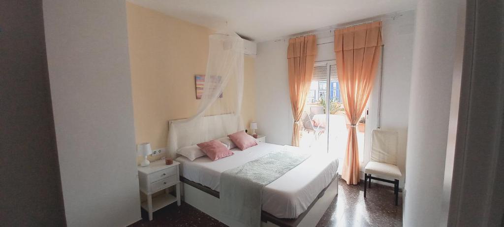 una camera bianca con un letto e una finestra di Cozy and sunny penthouse Fira BCN a Hospitalet de Llobregat