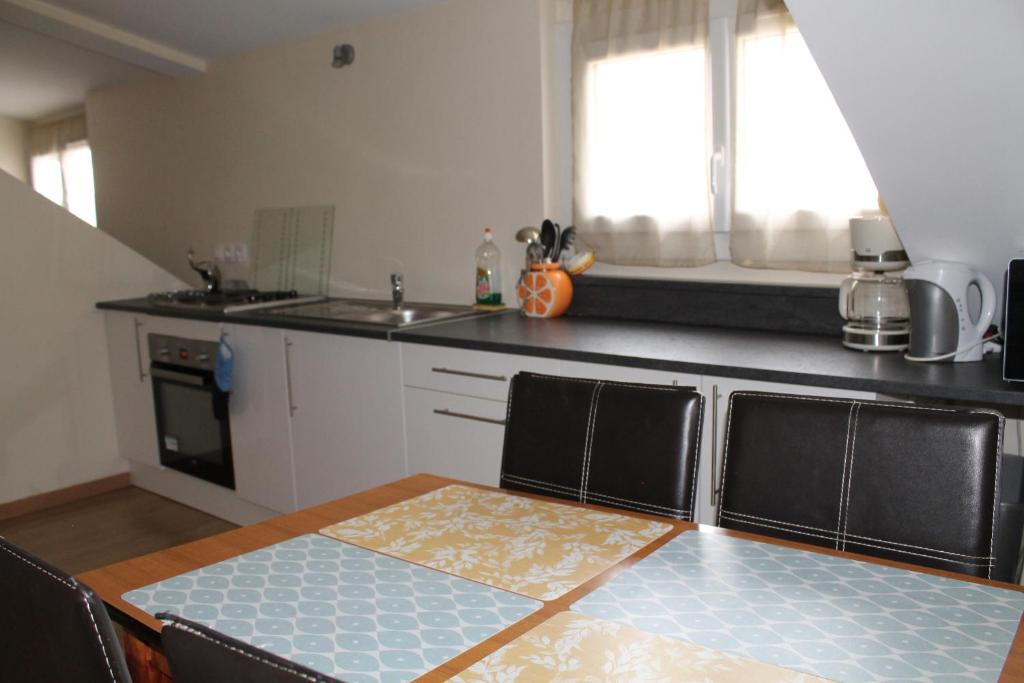 une cuisine avec une table et un comptoir dans l'établissement Location G&W, très proche sanctuaires II, à Lourdes