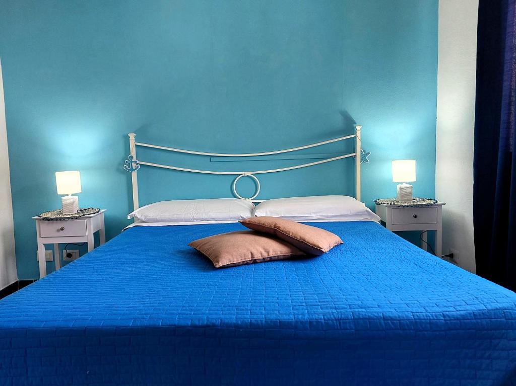 a blue bedroom with a blue bed with two pillows at La casa dei 4 venti in Ponza