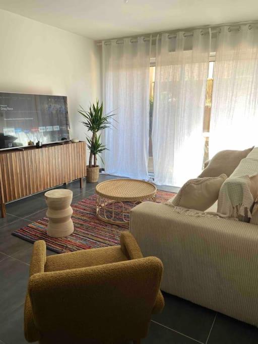 uma sala de estar com um sofá e uma mesa em Appartement T2 - Résidence de style Méditerranéen em Carqueiranne