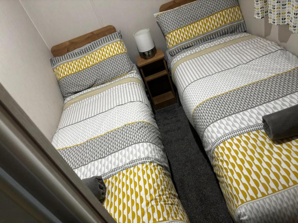 two beds sitting next to each other in a room at Ataraxia - Ocean Edge Resort - 8 Berth Accommodation in Heysham