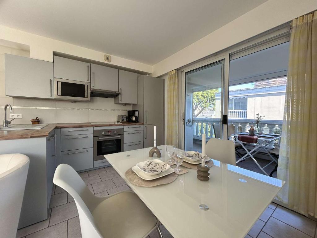 cocina con mesa blanca y sillas en una habitación en Appartement Antibes, 2 pièces, 4 personnes - FR-1-252-19, en Antibes