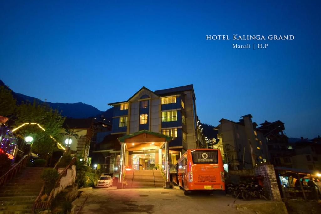 an orange bus parked in front of a building at WooibHotels The Kalinga Palace Manali in Manāli