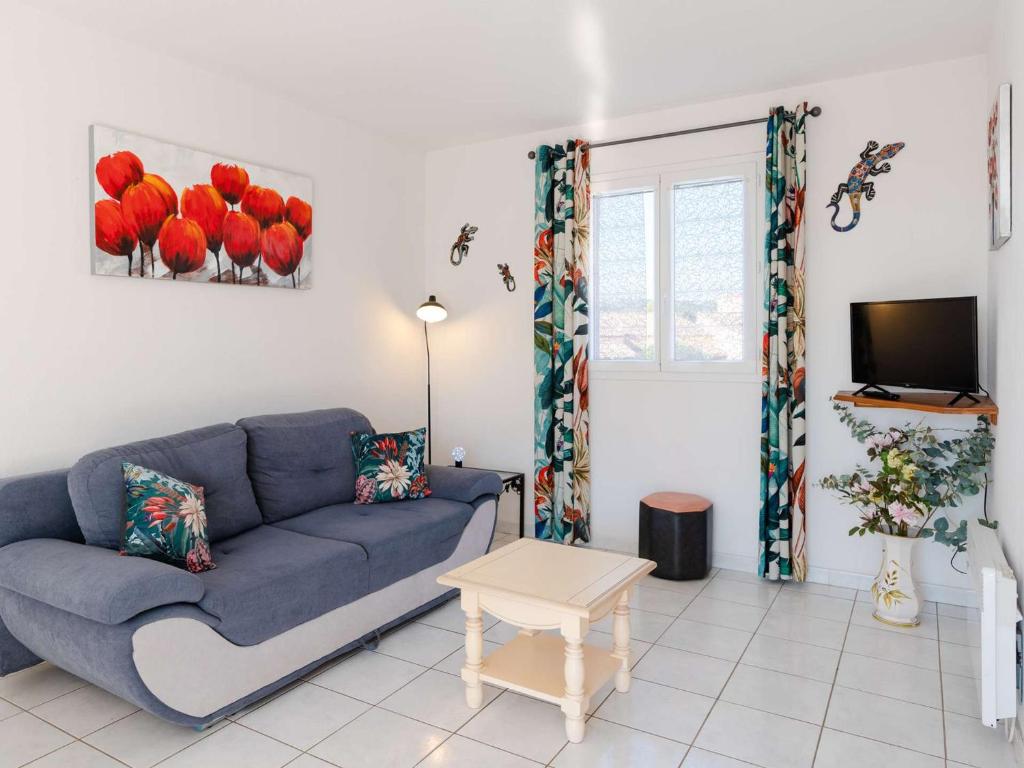 un salon avec un canapé bleu et une télévision dans l'établissement Appartement T4 Duplex 6 Pers, Balcon, Garage - Narbonne-Plage - FR-1-409-50, à Narbonne-Plage