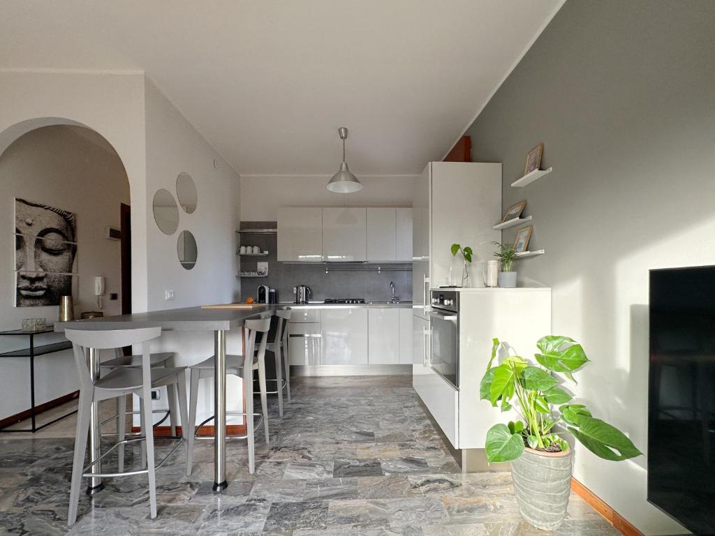 una cucina con mobili bianchi e tavolo di Appartamento 25 min da Venezia a Quarto dʼAltino