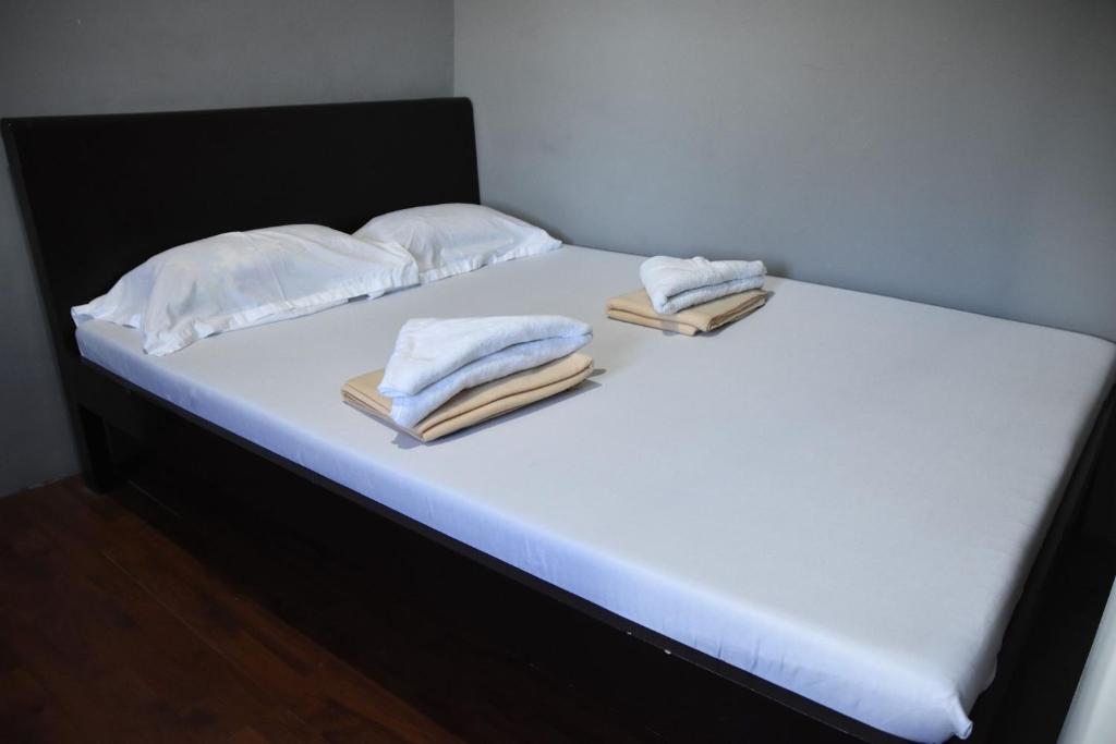 een bed met witte lakens en handdoeken erop bij Bethany Suites in Dipolog