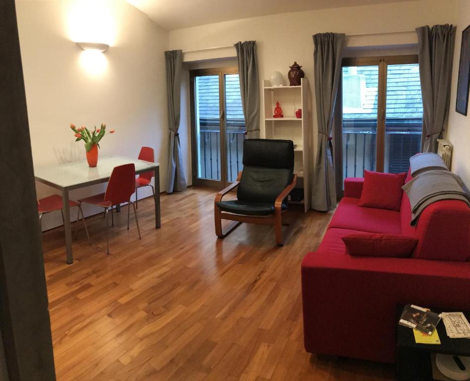 uma sala de estar com um sofá vermelho e uma mesa em Casa Nirvana em Gênova