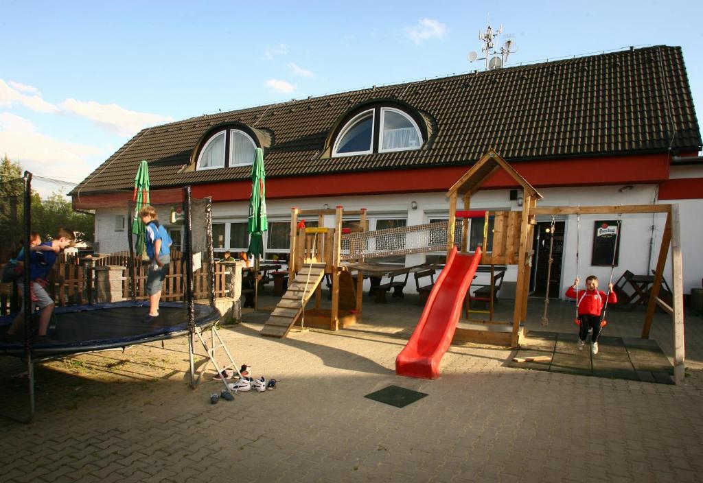 un parque infantil frente a una casa con tobogán en Penzion FAJN *** en Pardubice