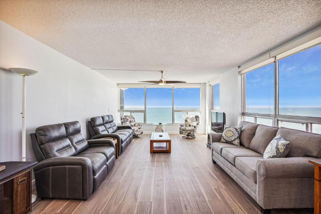 a living room with two couches and a television at Madeira Vista 601 in St. Pete Beach