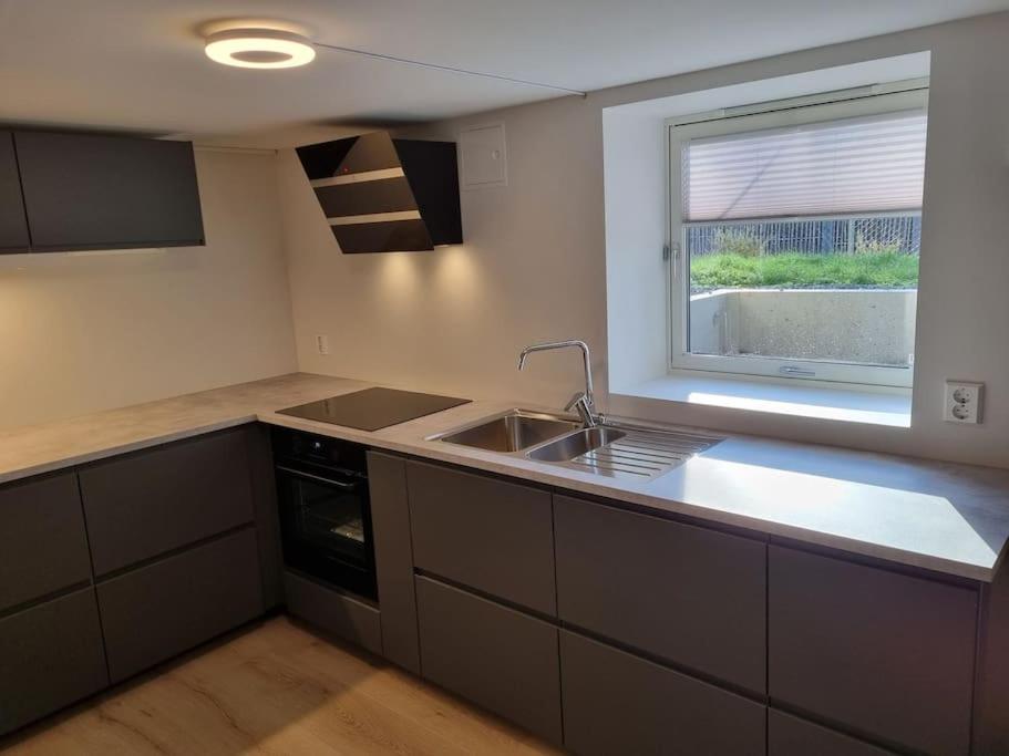 an empty kitchen with a sink and a window at Leilighet nær Trondheim by. in Trondheim