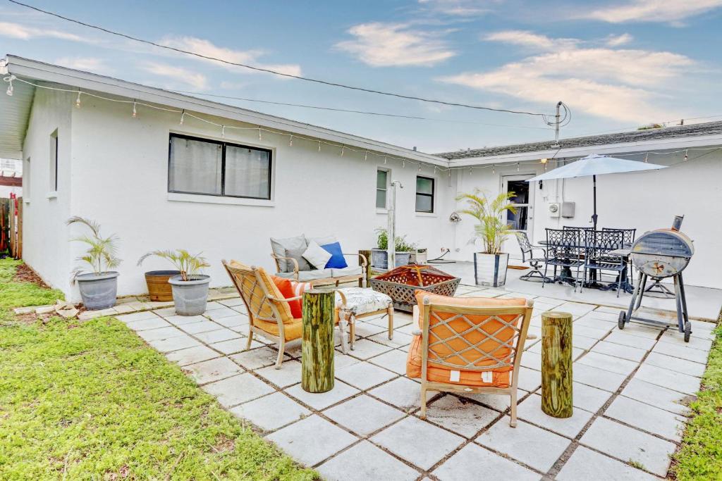 a patio with chairs and tables in front of a house at Blue Beach Cottage in St. Pete Beach