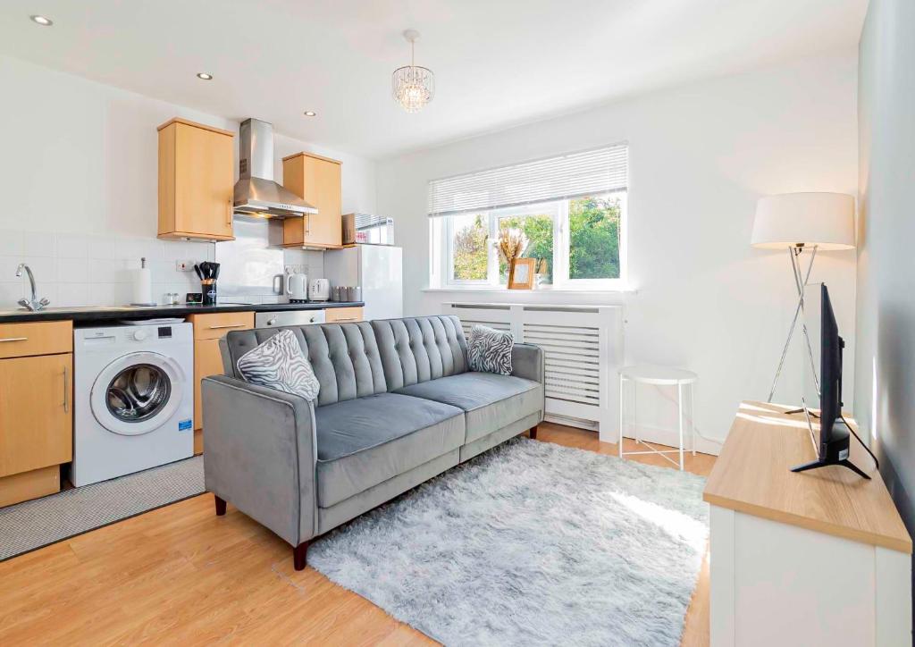 a living room with a couch and a kitchen at Eastleigh Serviced Apartment in Chandlers Ford