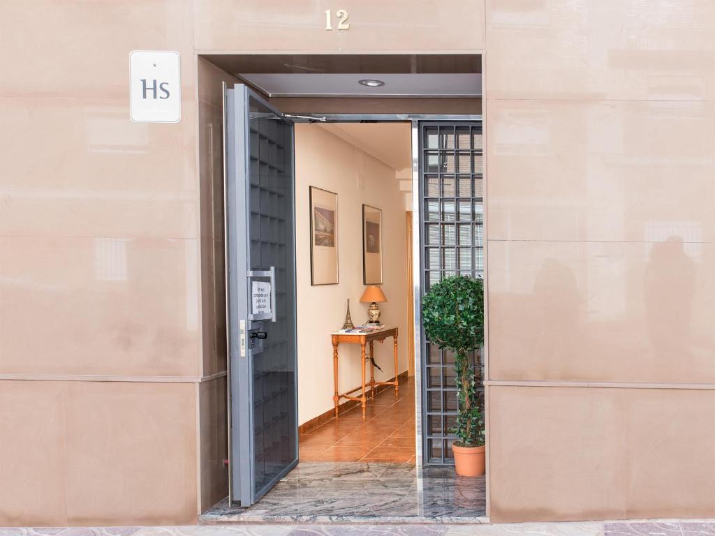 an open door of a building with a plant at Hostal Mitre Paterna in Paterna