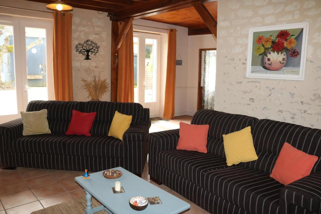 Sala de estar con 2 sofás y mesa en L'autre Monde en Faverolles