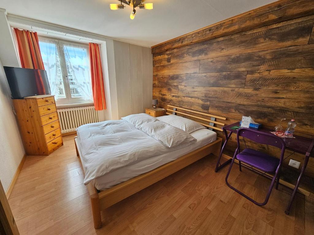 a bedroom with a bed and a wooden wall at Hotel Taverne zur Linde in Bischofszell