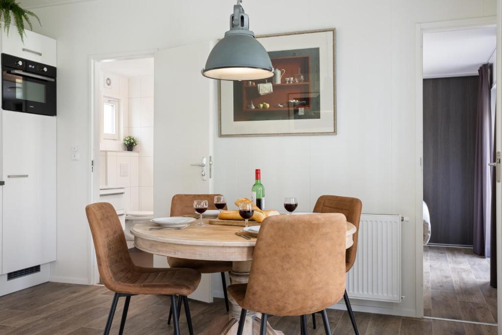 a kitchen and dining room with a table and chairs at Chalet 41 met twee badkamers in Oosterwolde