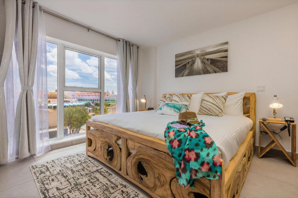 ein Schlafzimmer mit einem Bett und einem großen Fenster in der Unterkunft Unforgettable Where Excellence Convenience Meet in Oranjestad