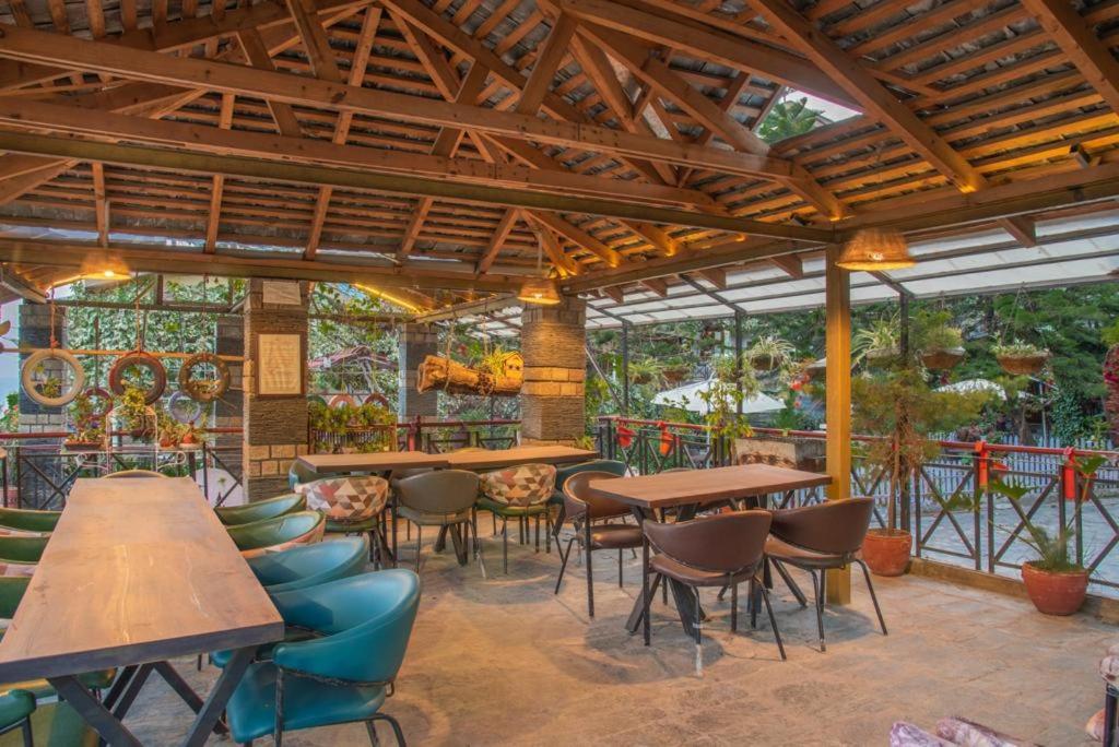 un patio avec des tables et des chaises dans un restaurant dans l'établissement Starlit Getaway, à Dharamshala