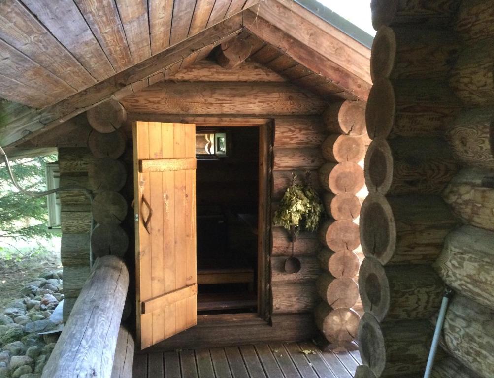 una puerta en el lateral de una casa de madera en Russet & Rowanberry - Rowanberry Holiday House en Kriilevälja