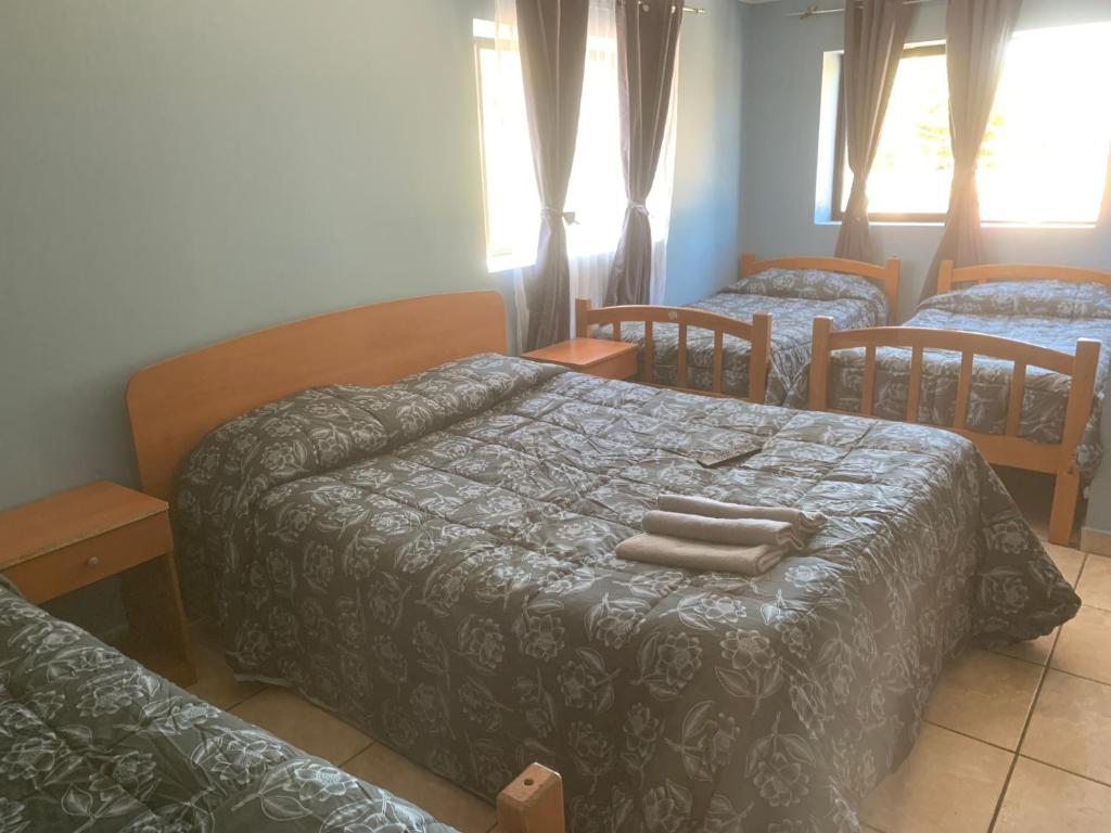 1 dormitorio con 2 camas y toallas en la cama en HOSTAL QUILPUE, en Quilpué