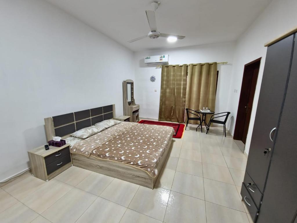 ein Schlafzimmer mit einem Bett und einem Tisch darin in der Unterkunft البيت الابيض in Mawāliḩ
