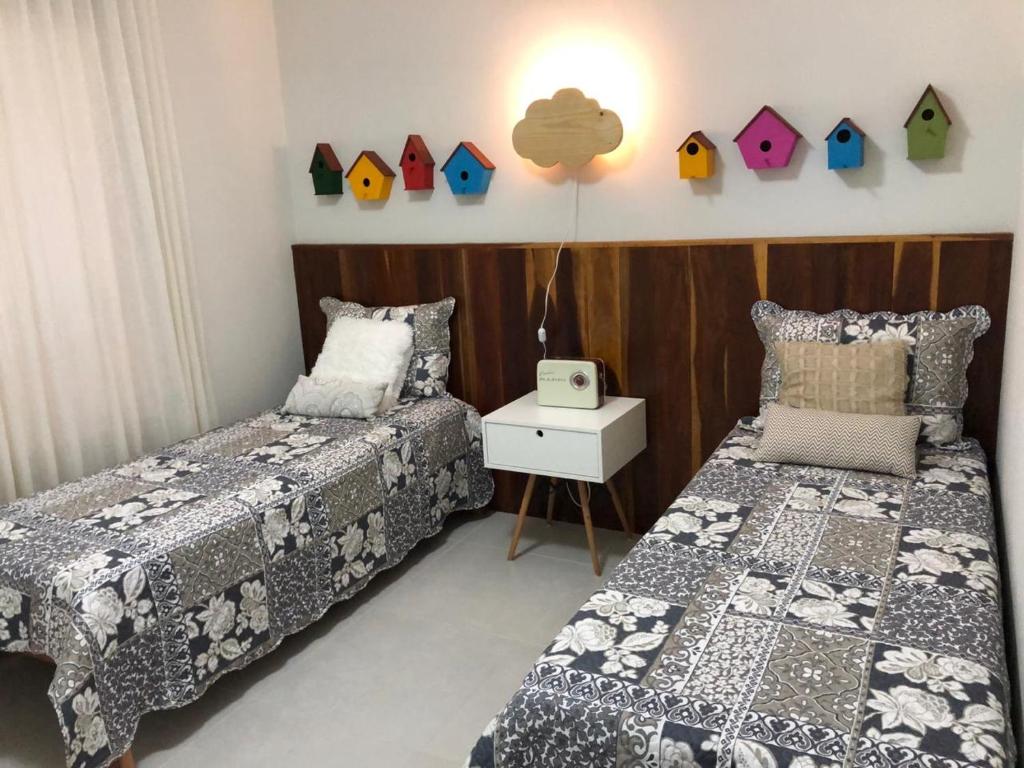 a bedroom with two beds and a table with a night stand at Villa das águas in Estância