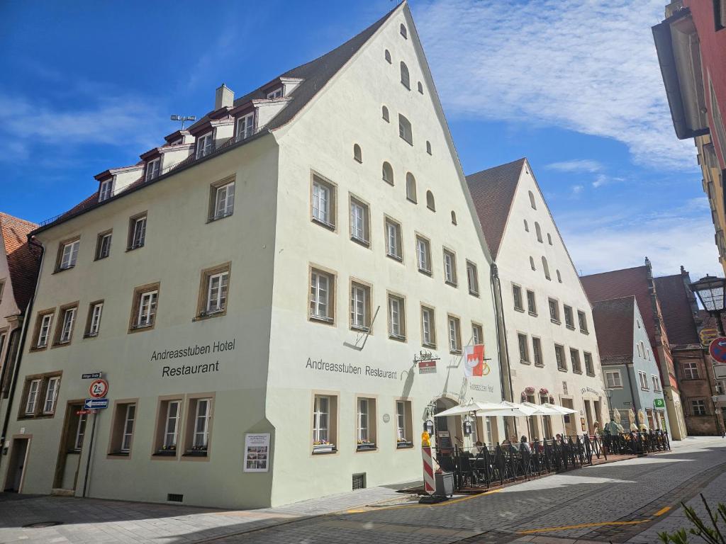 un grand bâtiment blanc sur le côté d'une rue dans l'établissement Hotel Andreasstuben, à Weißenburg in Bayern