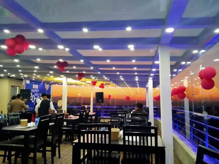 a restaurant with tables and chairs and red balloons at Hotel Suryansh Pvt Ltd in Heṭauḍā