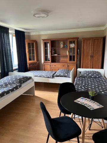 a bedroom with two beds and a table and chairs at Mieszkaj U Marty in Jaworzno
