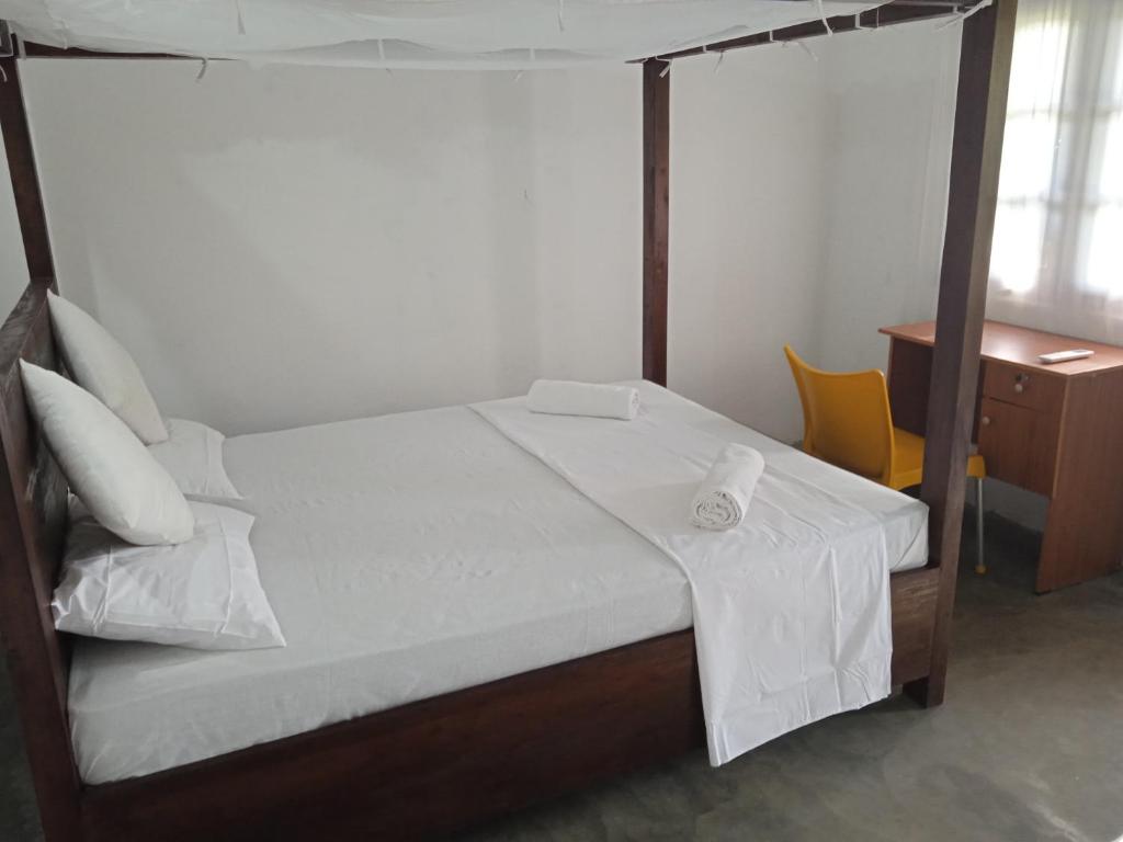 1 dormitorio con 1 cama con mesa y silla en Rangani Lagoon Resort, en Kalpitiya