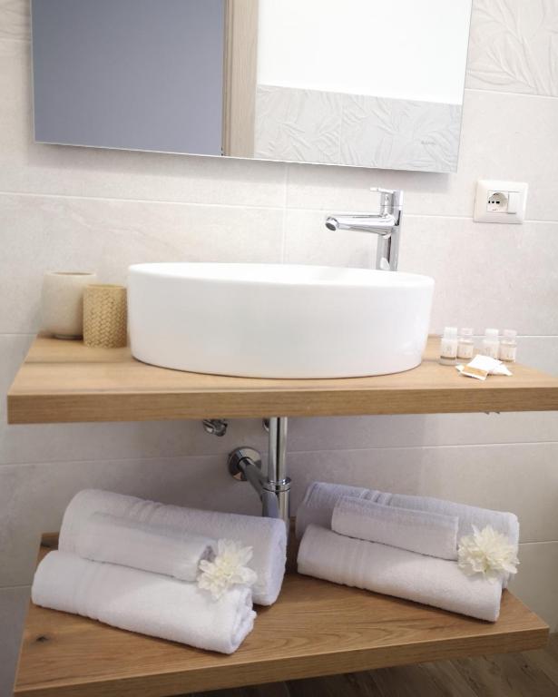 a bathroom with a sink and towels on a shelf at Villa Azzurra in Lampedusa