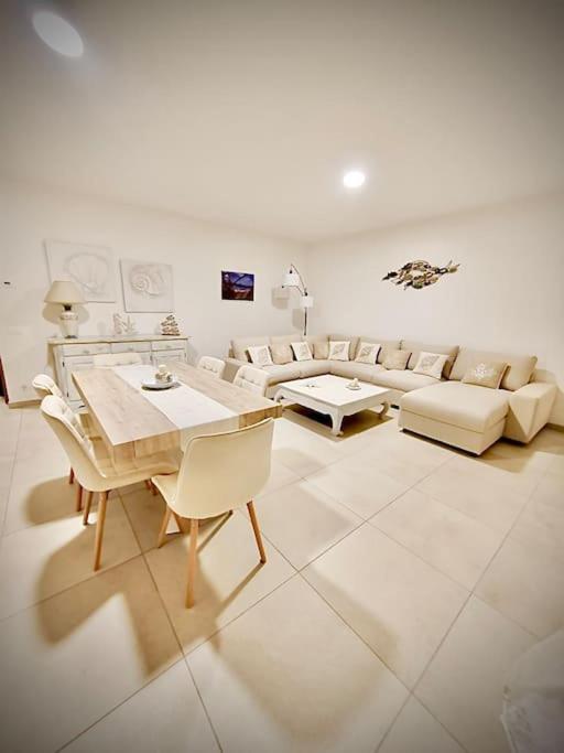 a living room with a couch and a table and chairs at Casa Gió Grazioso Appartamento a Porto Cervo in Liscia di Vacca