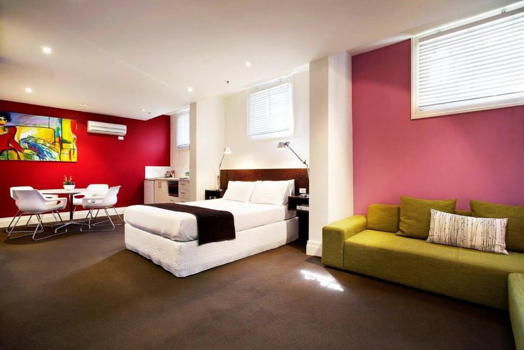 a bedroom with a bed and a couch and a table at Tolarno Hotel - Mirka’s Studio - Australia in Melbourne