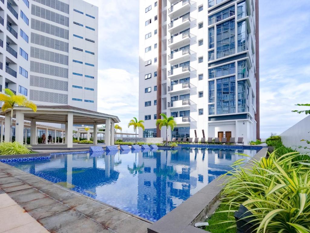 an image of a swimming pool with two tall buildings at 56sqm. Condo at Mactan Newtown w/Free Beach and Pool Access! in Lapu Lapu City