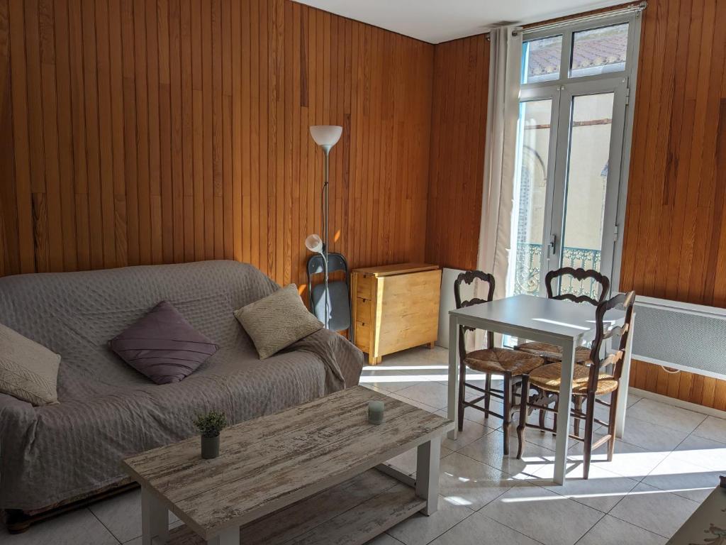 un salon avec un canapé et une table dans l'établissement La maison bleue, à Palavas-les-Flots