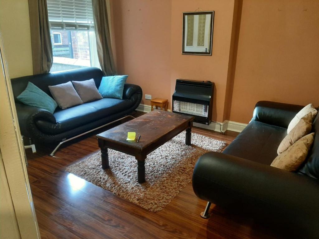 a living room with a couch and a coffee table at Nice 4 bedroom house in Nottingham