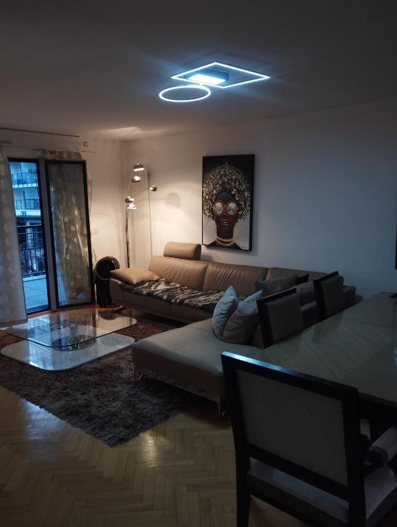 a living room with a couch and a glass table at BEAU APPARTEMENT in Suresnes