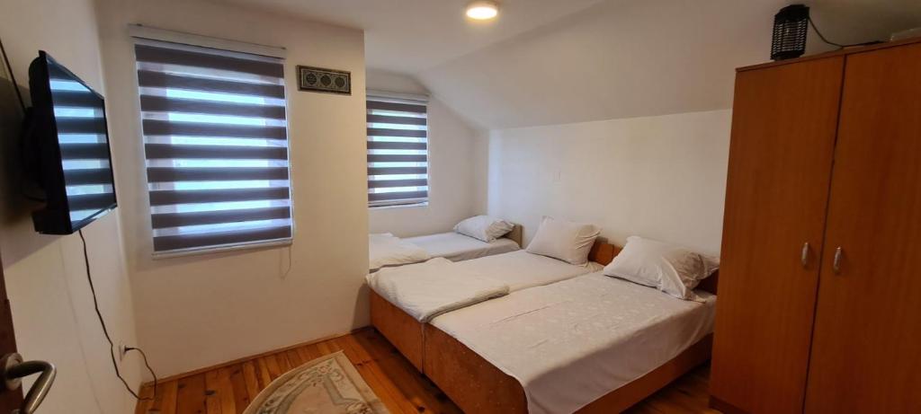 Habitación pequeña con 2 camas y ventana en Holiday Home White Rose, en Barice