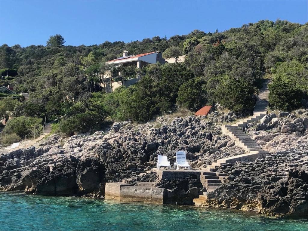 una casa en una colina rocosa junto al agua en Contessa robinson house, en Korčula